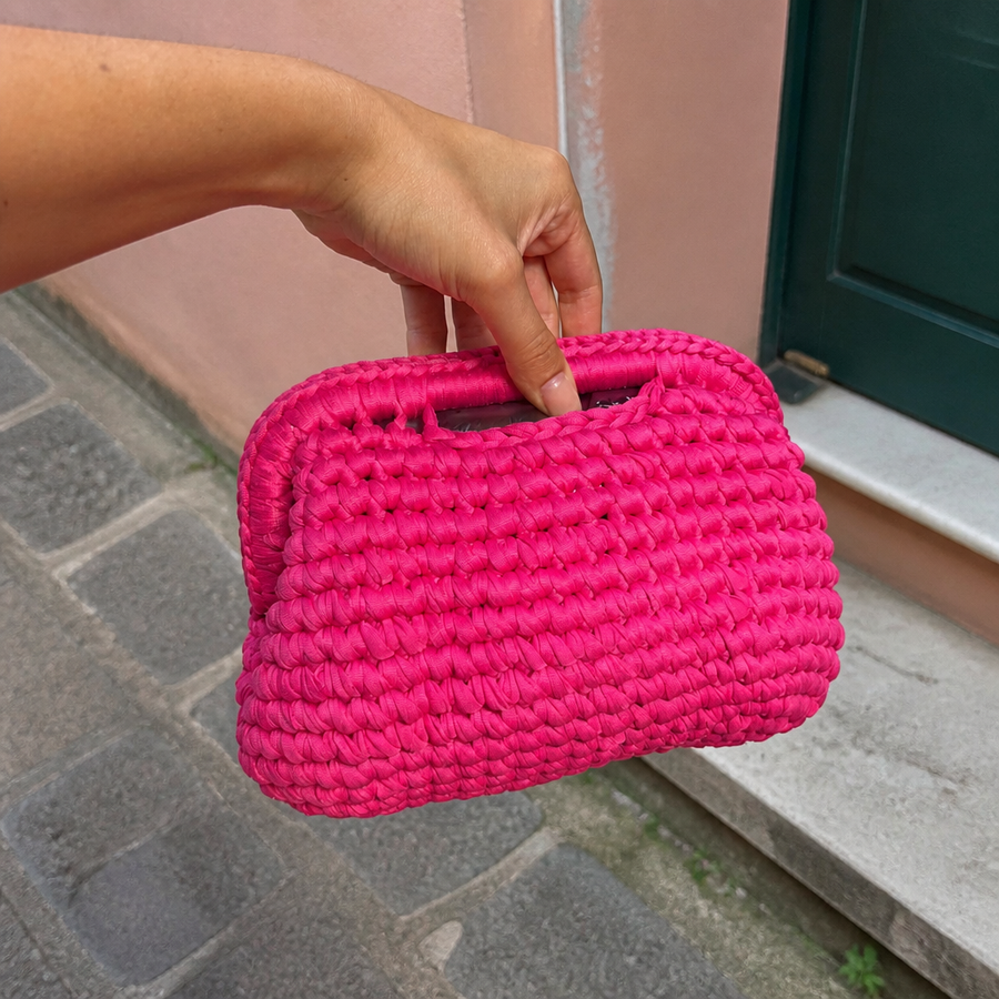 Borsa intrecciata fucsia, scatto iPhone con mano