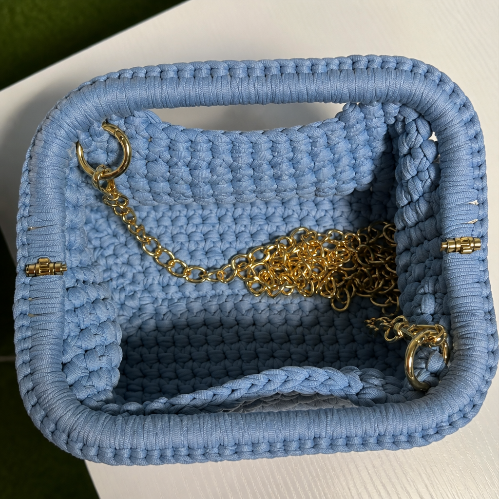 Interno clutch intrecciata azzurro con catena dorata stile fucsia