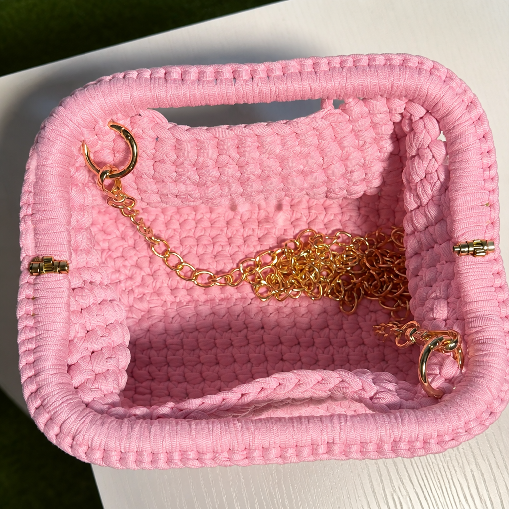 Interno clutch intrecciata rosa con catena dorata stile fucsia